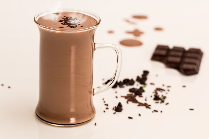 Photo de tasse de boisson cacaotée sucrée, soluble reconstituée, avec des carrés de chocolat, à droite