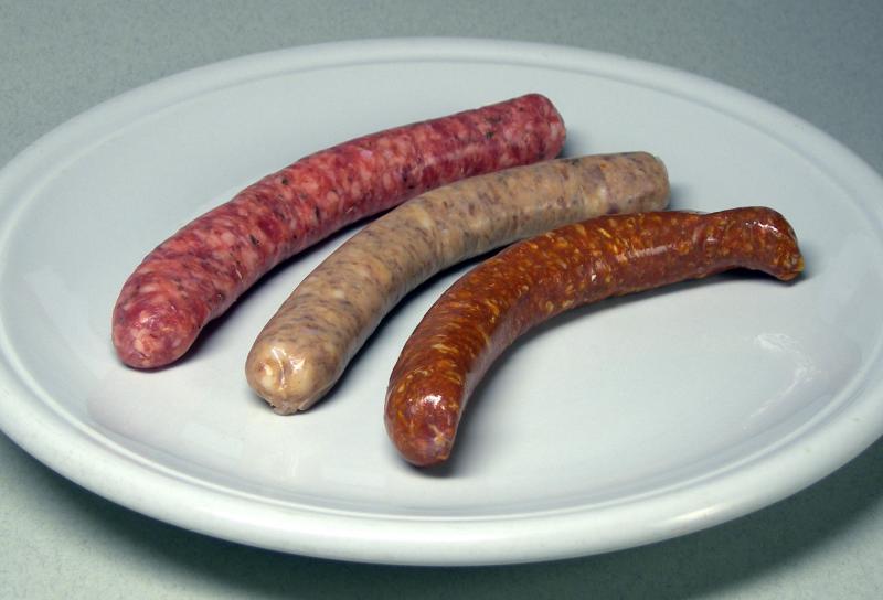 Photo d'une assiette de chipolatas et d'une merguez, crues.