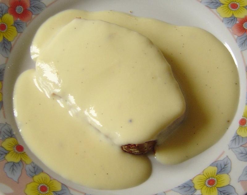 Photo d'une assiette de crème anglaise, préemballée, nappant une tranche de pain d'épices.                                                                    