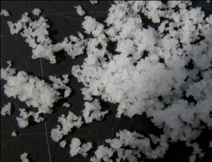 Photo de fleur de sel sur un plateau noir.
