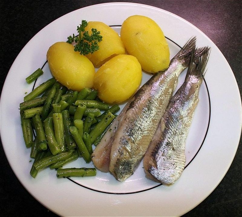 Photo d'une assiette de hareng fumé à l'huile avec son assortiment de légumes