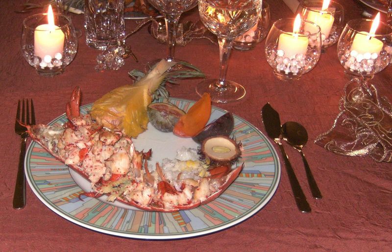 Photo d'une assiette de homard, cuit à l'eau, accompagné de fruits exotiques.