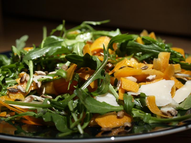 Salade de roquette, crue, accompagnée de carottes et de parmesan.