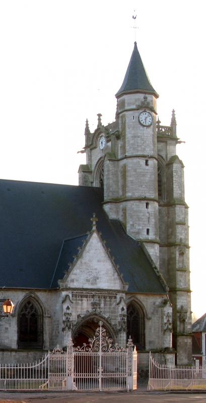 L'église aperçue depuis l'angle de la Rue des Écoles et de la Rue de l'Église. .