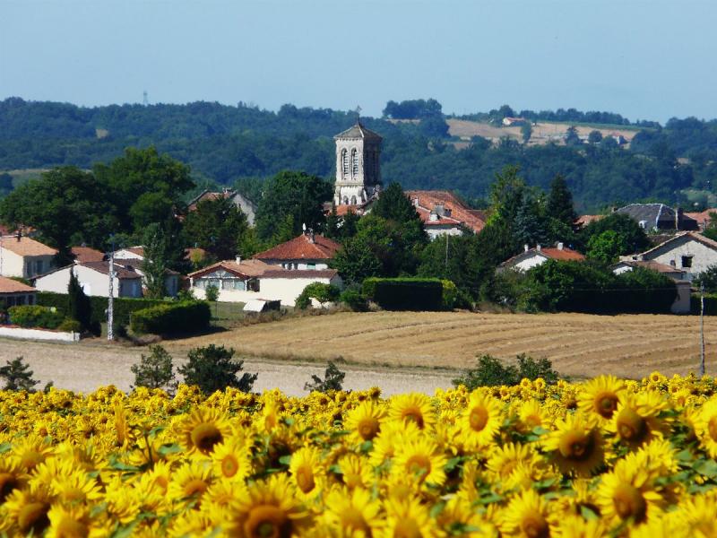 Le bourg de Gout-Rossignol, ondulant à travers l'atmosphère estivale surchauffée.