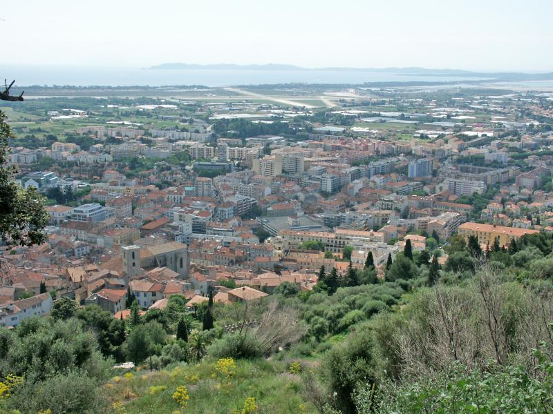 Hyères, vue prise du château en direction du sud. Sur la gauche, la vieille ville avec l'église Saint-Paul. En arrière-plan, l'aéroport de Toulon-Hyères. Sur la droite, la presqu'île de Giens. Au fond, l'île de Porquerolles.