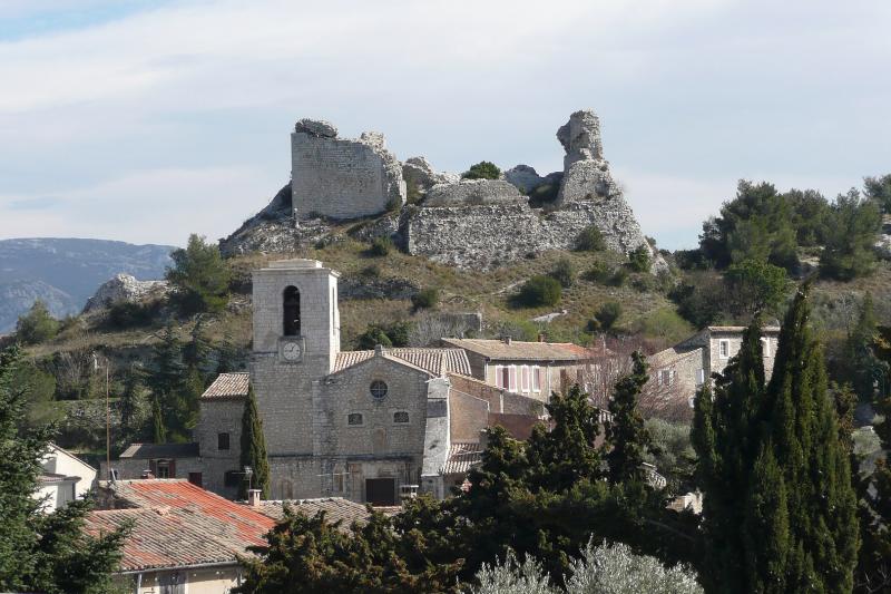 Les ruines du château du duc de Guise dominent la localité. Plus en avant, sur la gauche, se dresse l'église Notre-Dame de l'Assomption.