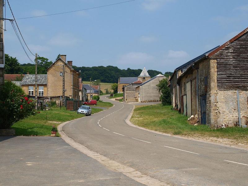 La rue principale du village. La mairie est le premier bâtiment à gauche ; l'église est au loin, à Verrières,  dans le département des Ardennes.