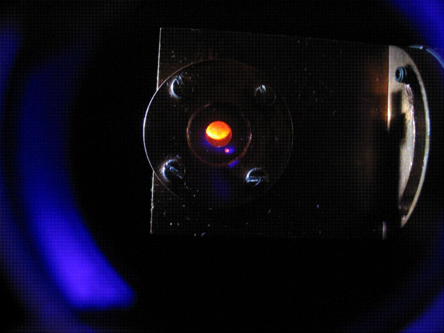 Fluorescence orange induite par laser dans une solution de complexe tris(hydrotris)pyrazolylborato-Cm(III), avec une longueur d'onde d'excitation de 396,6 nm.