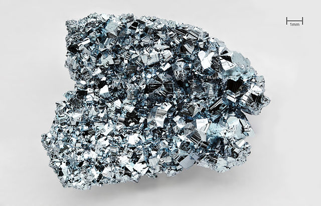 Cristaux d'Osmium (Os), produit par réaction de transport chimique dans une atmosphère de chlore. Masse : 2,2 g, pureté ≥ 99.99%.