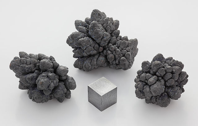 Nodules de Plomb, raffinés par électrolyse, à côté d'un cube d'1 cm³ de plomb pure à plus de 99,9 %