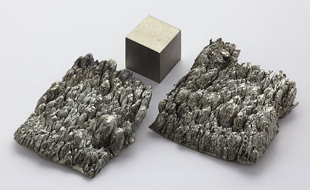 Scandium, sublimé dendritique et cube de 1 cm³.