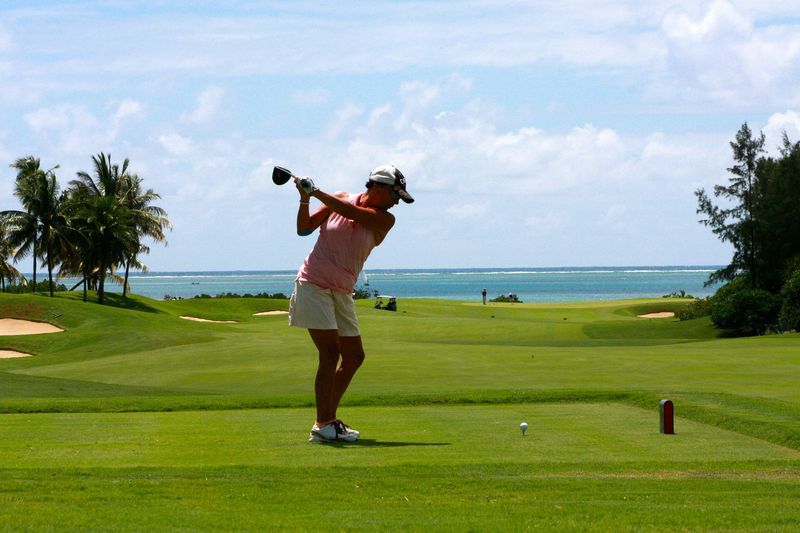 Une golfeuse tir une balle de golf à l'aide d'un club sur l’île Maurice