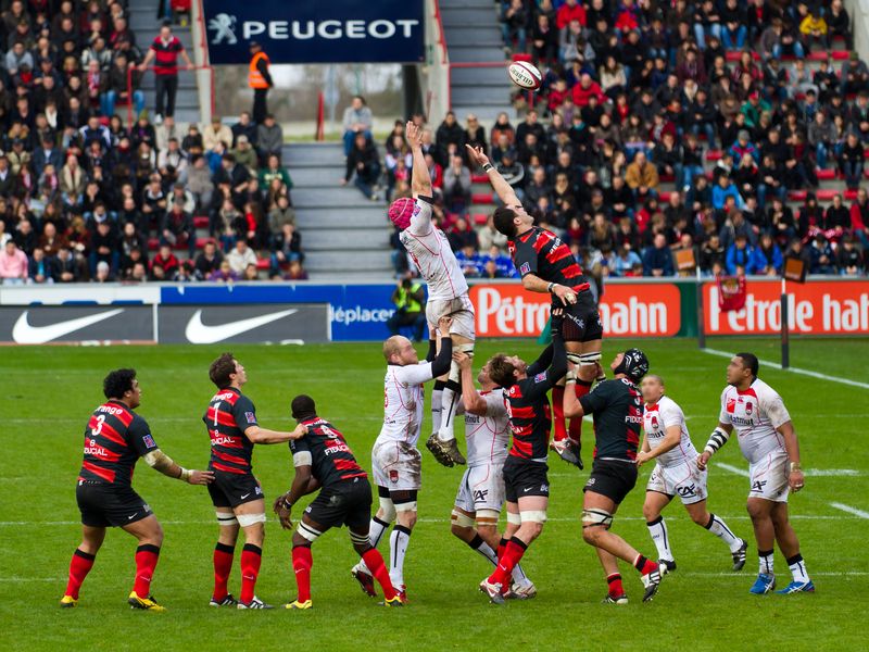 Deux équipes tentent d'attraper le ballon ovale lors d'un match de rugby